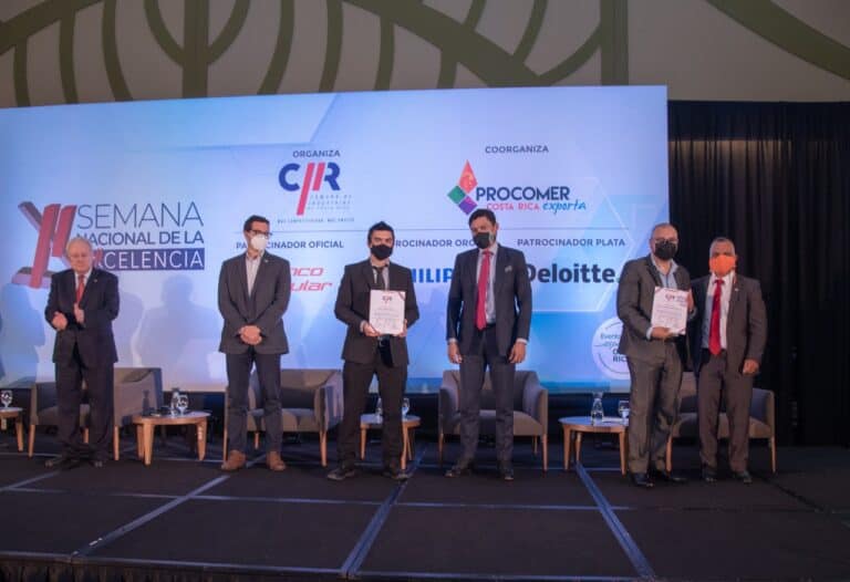 Ceremonia de entrega de premios de la Semana Nacional de la Excelencia con representantes de empresas en escenario, organizado por CICR y PROCOMER