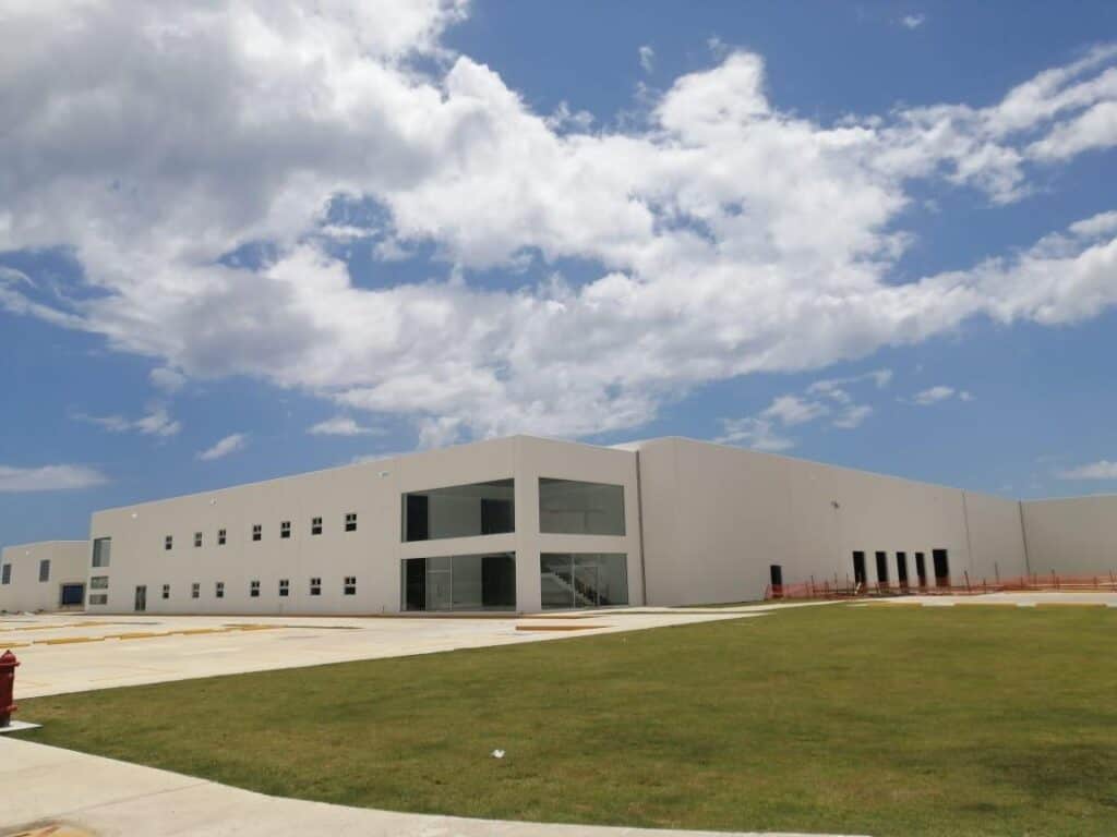 Instalación industrial moderna con patio verde y cielo despejado