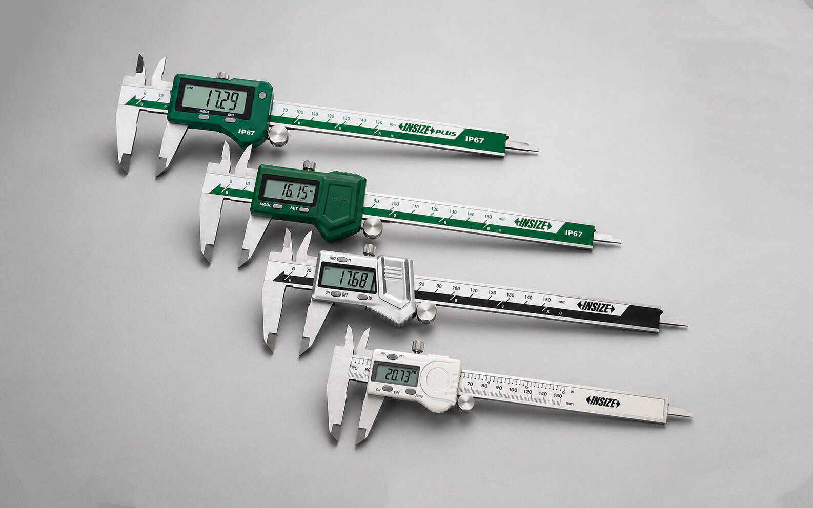 Calibres digitales INSIZE dispuestos en composición diagonal sobre fondo neutro gris, mostrando instrumentos de medición dimensional de alta precisión para uso industrial y de laboratorio.