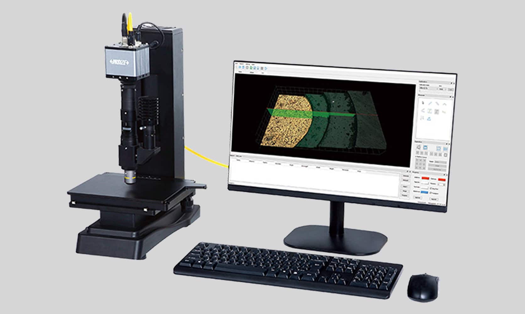 Comparador óptico digital INSIZE con sistema de medición vertical, mesa de inspección y monitor externo mostrando análisis de superficie, acompañado de teclado y ratón, sobre fondo gris claro uniforme.
