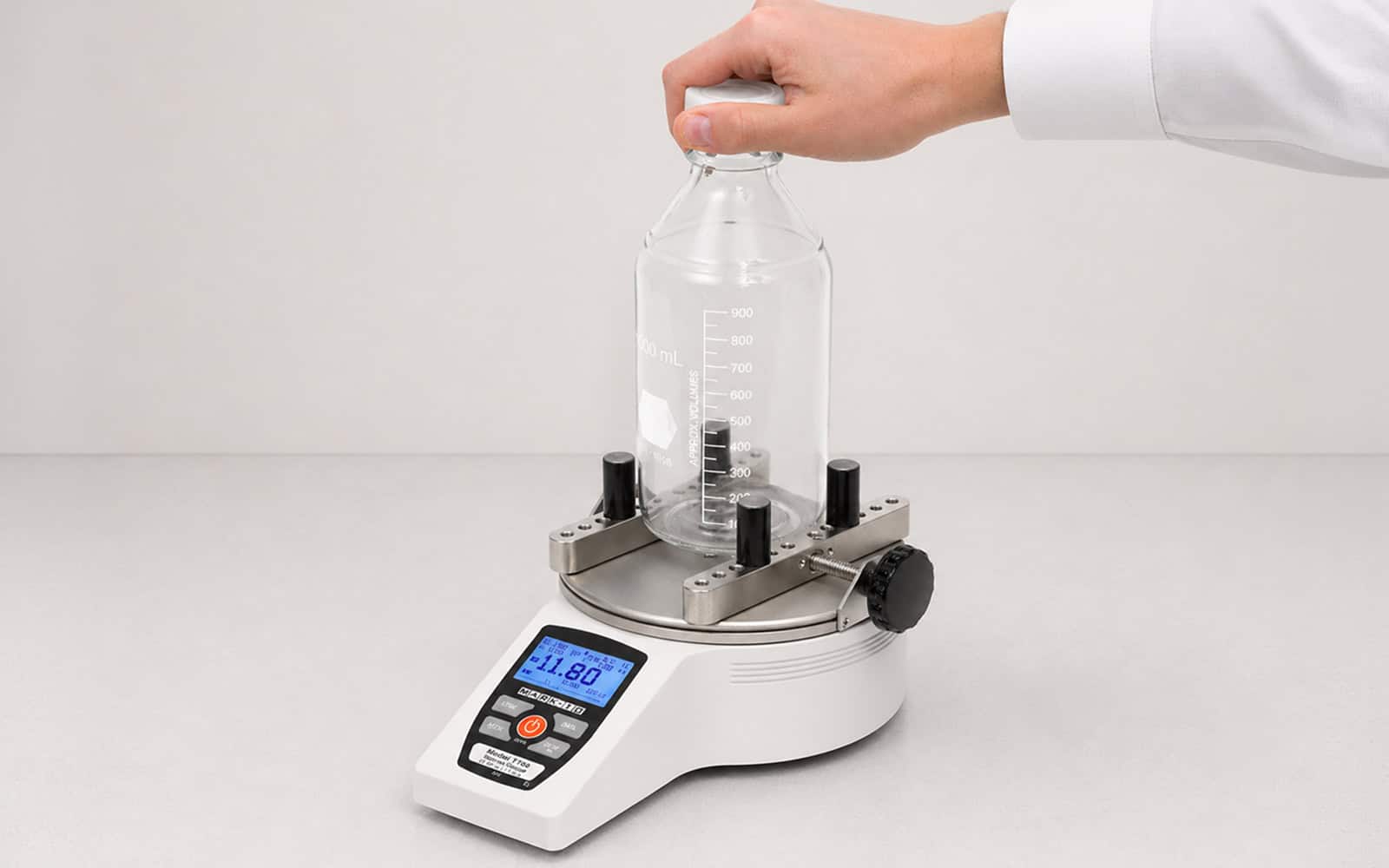 Medidor de torque digital Mark-10 para ensayo de apertura de envases con botella de laboratorio sobre base de sujeción ajustable