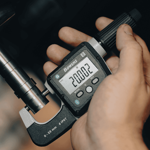 Micrómetro digital Bowers Digimic utilizado para medición externa de precisión en componente metálico durante control dimensional industrial.